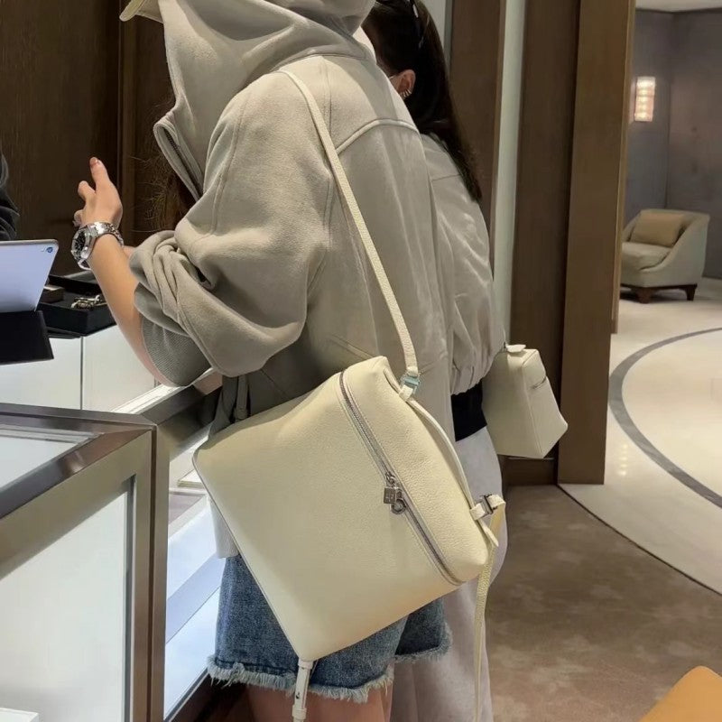 Person holding a white handbag in an indoor setting